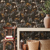Dark wildflower wallpaper styled in an entryway with natural wood furniture and woven accents