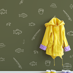 Fishing decals on green wall with yellow raincoat and boots – simple outline fish and fishing gear wall stickers for kids’ mudroom decor.
