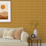 Mustard stripe wallpaper behind a beige sofa with earthy pillows and framed artwork in a cozy living room