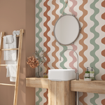 Retro wavy stripe wallpaper in muted earth tones installed in a modern bathroom with wood vanity