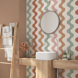 Retro wavy stripe wallpaper in muted earth tones installed in a modern bathroom with wood vanity
