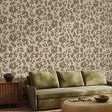 Earthy brush stroke floral wallpaper styled in a living room with green sofa and natural wood accents