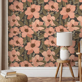 Floral wallpaper with pink flowers and green leaves in a room with a wooden stool and lamp.