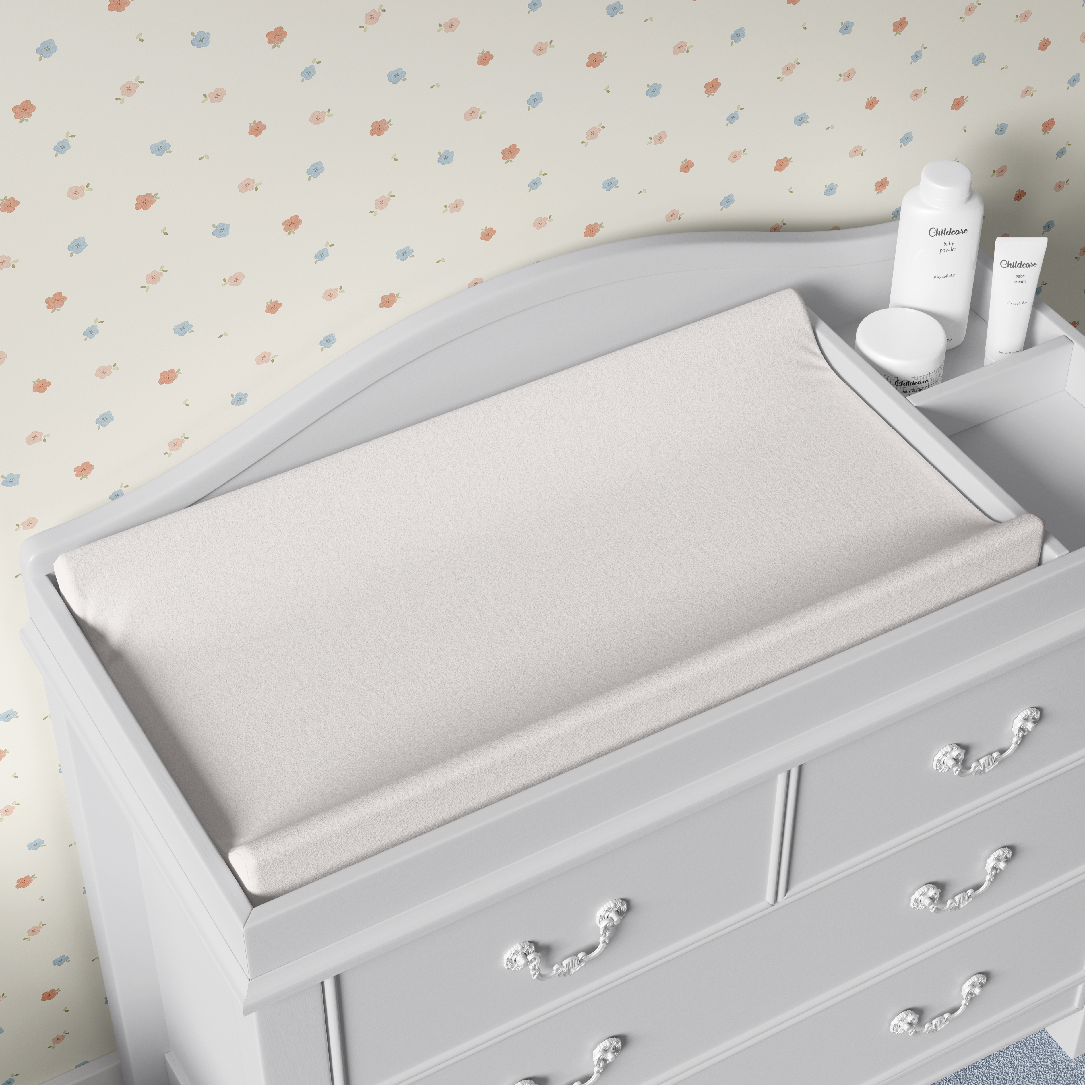 close up of pastel flower wallpaper above white nursery changing table