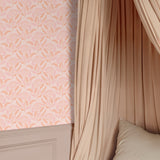 Bloomfield wallpaper behind canopy bed in soft peach and blush tones