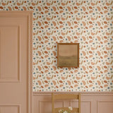 Playful shapes wallpaper in abstract retro tones of terracotta, beige, olive green, and blue, styled in a classic entryway with pink wainscoting