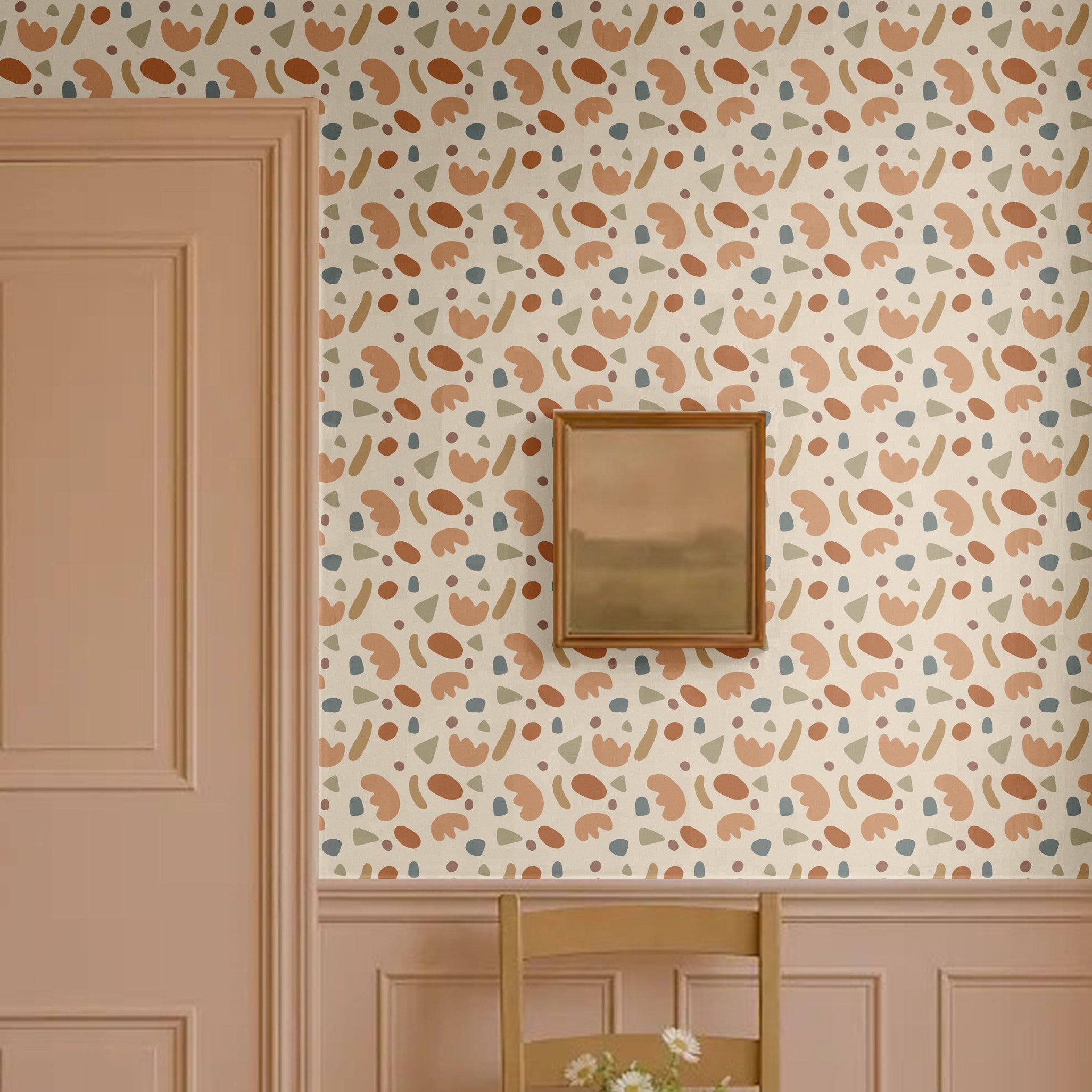 Playful shapes wallpaper in abstract retro tones of terracotta, beige, olive green, and blue, styled in a classic entryway with pink wainscoting