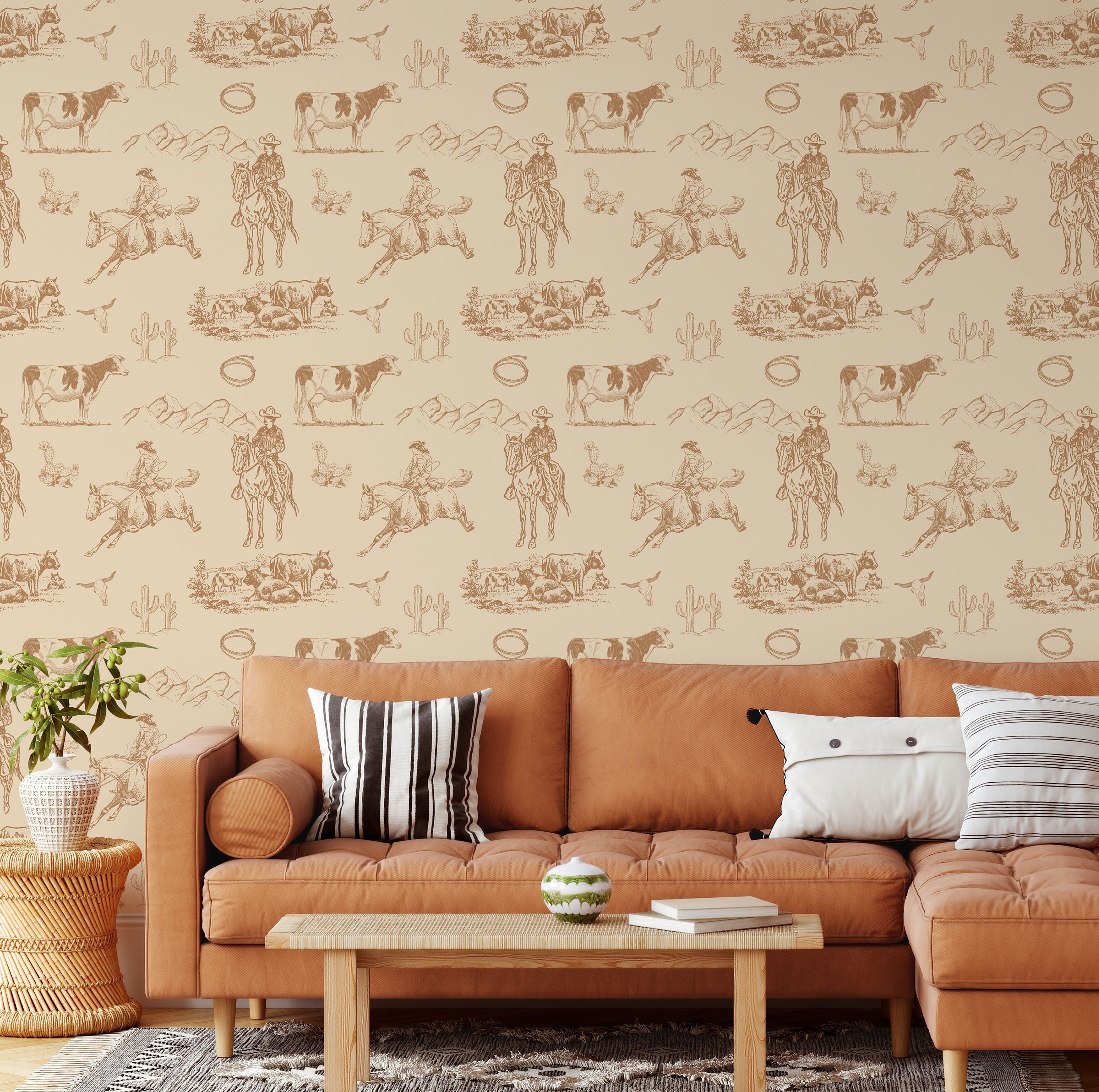 Neutral western cowboy wallpaper styled behind caramel leather sectional sofa with ranch inspired decor