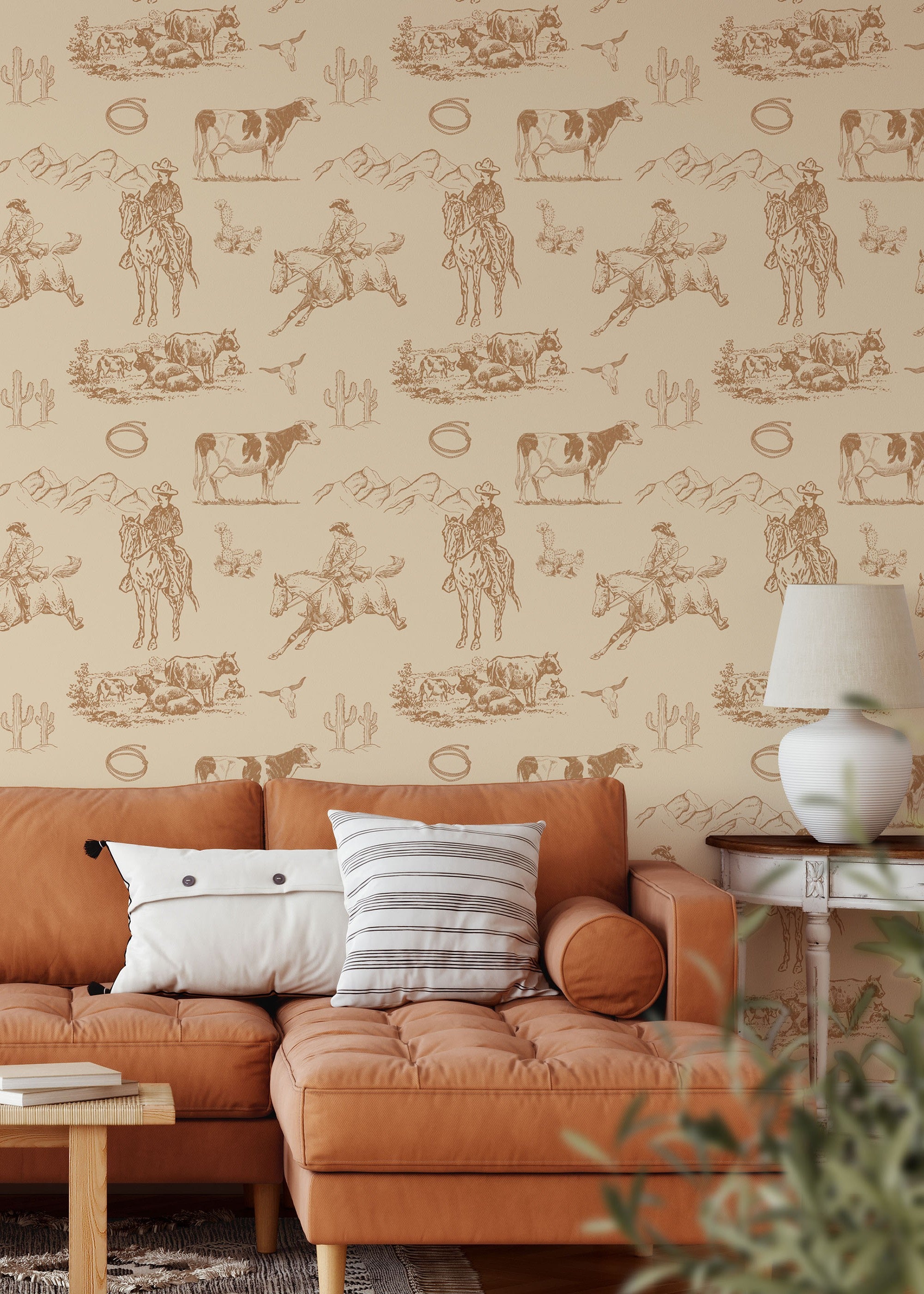 Sage Saddle western wallpaper with cowboy, horse and cattle illustrations in neutral beige and brown behind wood console table