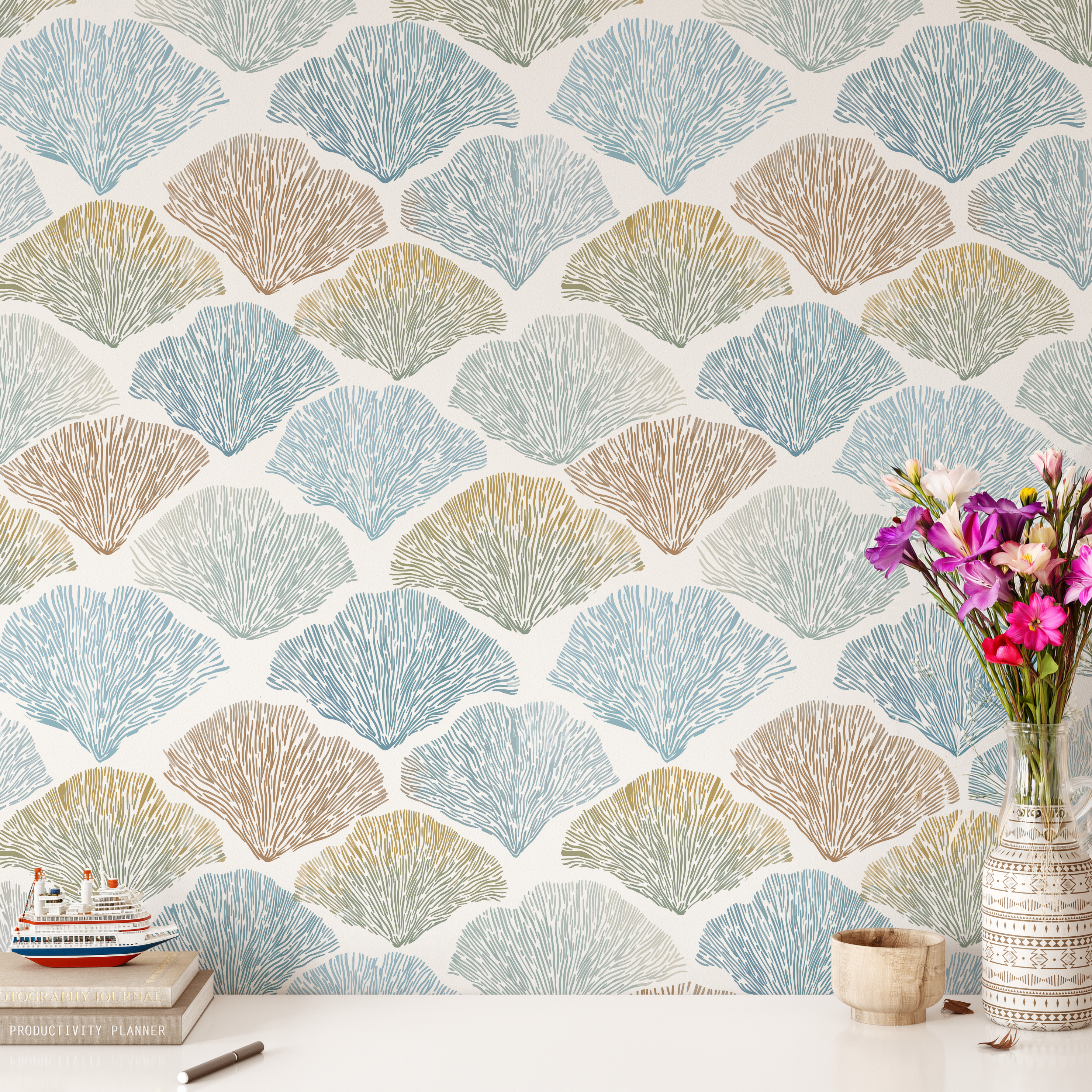 coastal shell wallpaper with blue and tan fan pattern, beach house decor styled with flowers and neutral accessories