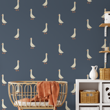 Goose wall decals on navy blue wall with rattan crib, wicker baskets, and nursery storage.