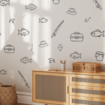 Fishing decals on white wall above wicker cabinet, minimalist fish and fishing gear wall decals for lake house or cabin wall art.