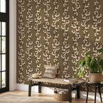 Snowberry Trail wallpaper installed behind a green sofa, highlighting the vertical botanical stripe design.