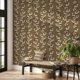 Snowberry Trail wallpaper installed behind a green sofa, highlighting the vertical botanical stripe design.