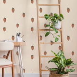 Strawberry wallpaper styled in a room with a wooden ladder shelf, trailing plants, and a woven basket planter