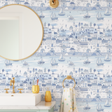 Close-up of light blue nautical wallpaper with sailboats and illustrated coastal homes