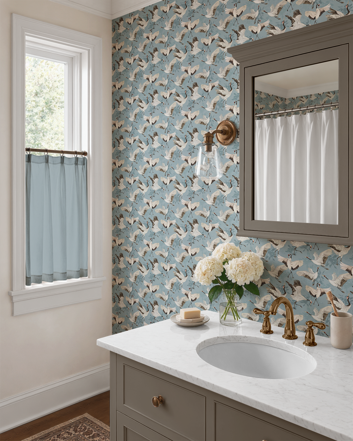 Tsuru Sky wallpaper in a bright bathroom with flying Japanese cranes, brass fixtures, and a marble vanity.