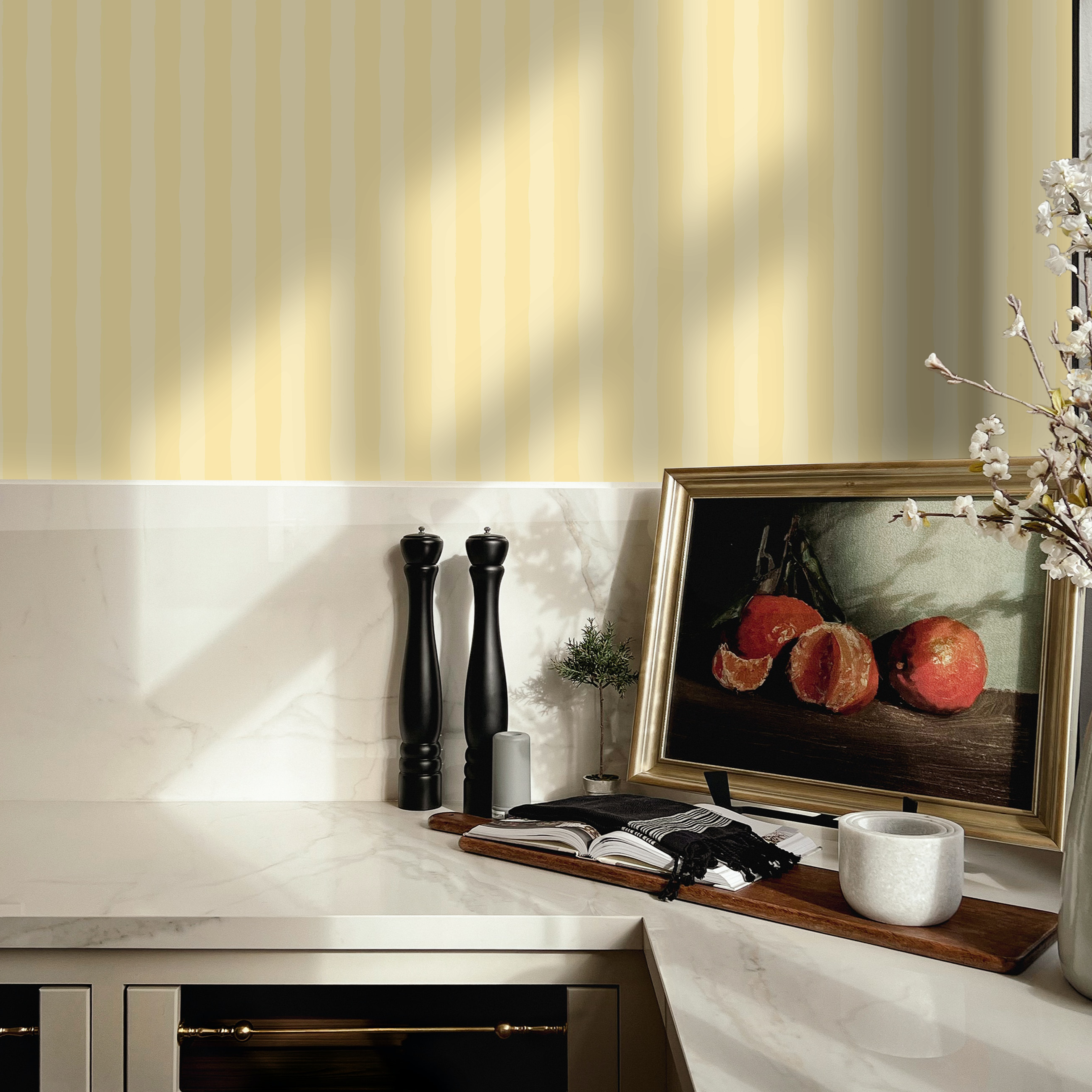 Yellow stripe wallpaper styled in a modern kitchen with marble backsplash and framed art.