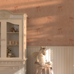 Kids’ room with Pink Bow Vintage Wallpaper, sunlight streaming across walls, white cabinet, and plush unicorn toy.