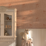 Kids’ room with Pink Bow Vintage Wallpaper, sunlight streaming across walls, white cabinet, and plush unicorn toy.