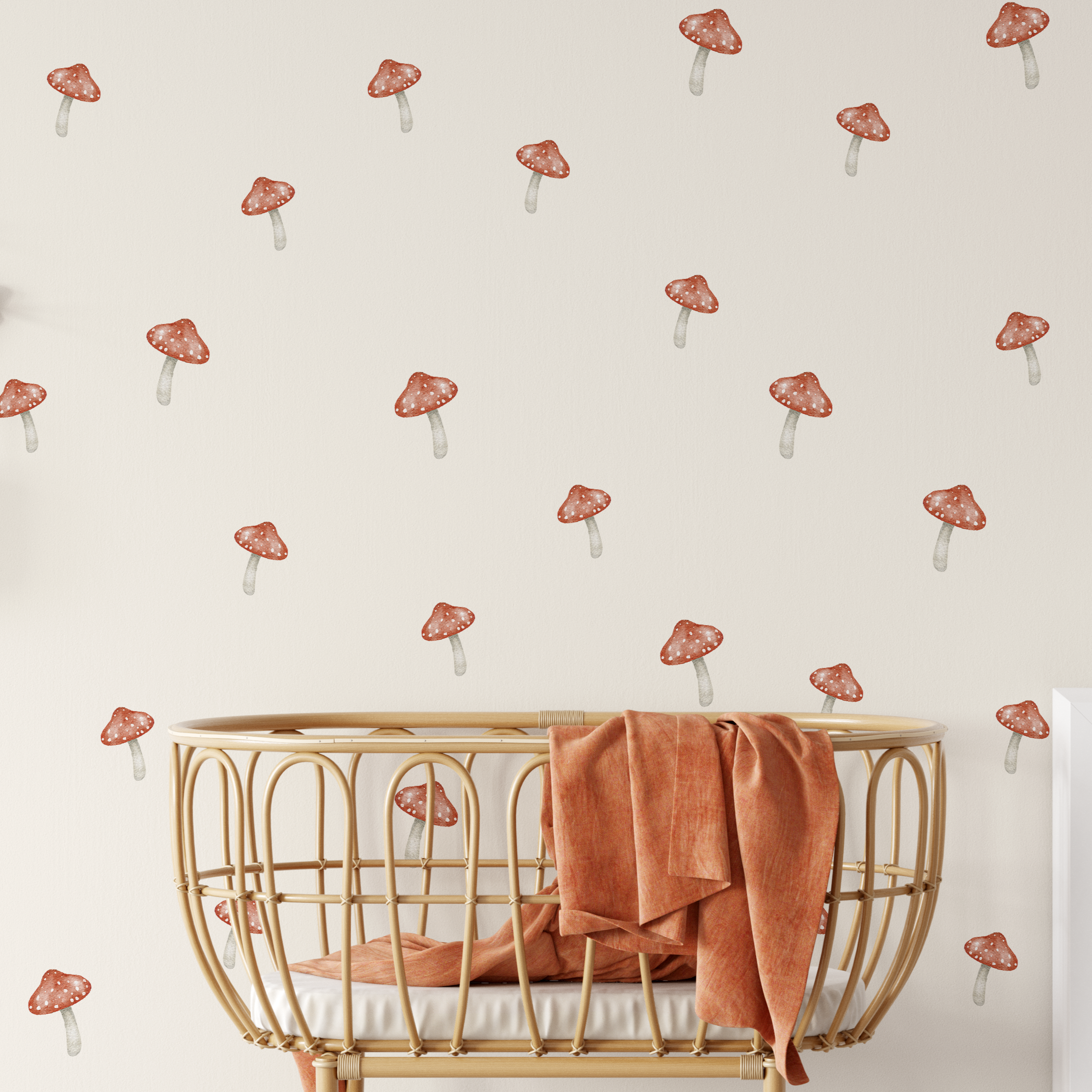 Whimsical red mushroom wall decals in a neutral nursery with rattan bassinet and woodland decor