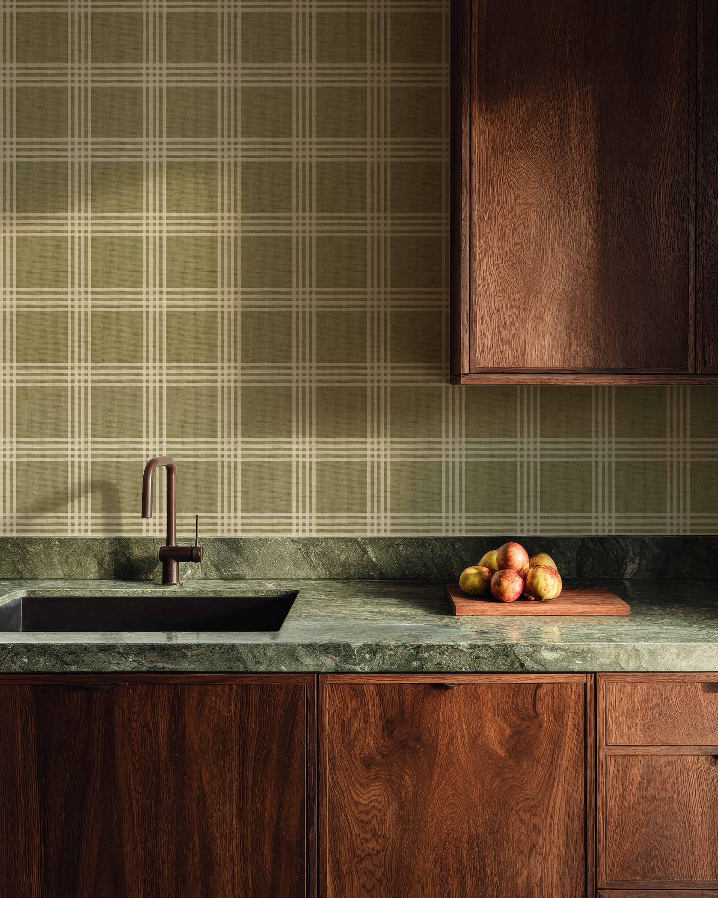 Kitchen with green plaid wallpaper, wooden cabinets, and a marble countertop.