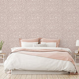 Bedroom with floral wallpaper, pink bed frame, and white bedding.