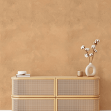 A boho-inspired room styled with Arizona limewash wallpaper, a light rattan dresser, white ceramic vase with cotton stems, and a cozy minimalistic aesthetic.