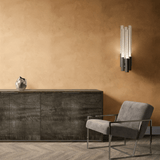 A sleek modern office space featuring Arizona limewash wallpaper, a gray armchair, and a dark wood cabinet accented with a modern wall sconce.