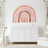 A nursery with an Autumn Rainbow wall decal above a white dresser. The neutral tones of the room are enhanced by the soft, warm colors of the rainbow, creating a calming and stylish environment for a baby.