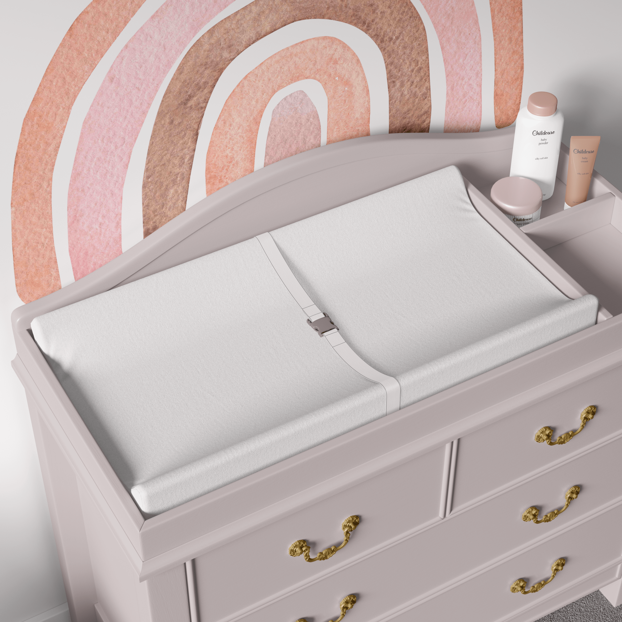 A changing table with an Autumn Rainbow wall decal above it. The pastel pinks and natural browns of the rainbow design complement the soft tones of the nursery decor, adding a soothing touch to the space.