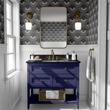 A chic bathroom with black heron-patterned wallpaper, a navy blue vanity, gold fixtures, a rectangular mirror, and brass sconces.