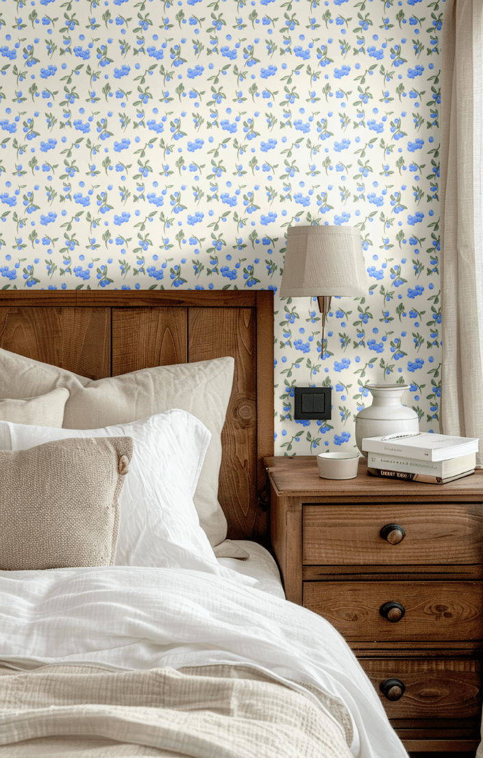 Bedroom decor featuring Blueberry Fields wallpaper behind a wooden bed frame, bringing a rustic yet fresh look with soft blue floral patterns