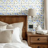 Bedroom decor featuring Blueberry Fields wallpaper behind a wooden bed frame, bringing a rustic yet fresh look with soft blue floral patterns