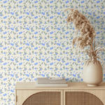 Close-up view of Blueberry Fields wallpaper in a bedroom, featuring vibrant blue flowers against a neutral background with dried floral accents