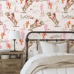Cozy bedroom with a single bed against a Coral Rodeo wallpaper accent wall, designed with cowgirl and desert motifs in pink and coral hues