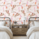 Western-themed girls' bedroom decorated with Coral Rodeo wallpaper as an accent wall, showcasing cowgirl illustrations with desert landscapes and cactus details