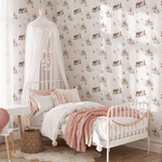 A cozy girl's bedroom featuring a white metal bed with pink and white bedding, a canopy with fairy lights, and cowgirl-themed wallpaper showcasing cowgirls and horses on a white background.