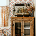 A rustic decor room featuring wooden furniture, a vintage painting, and floral damask wallpaper