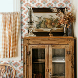 A rustic decor room featuring wooden furniture, a vintage painting, and floral damask wallpaper