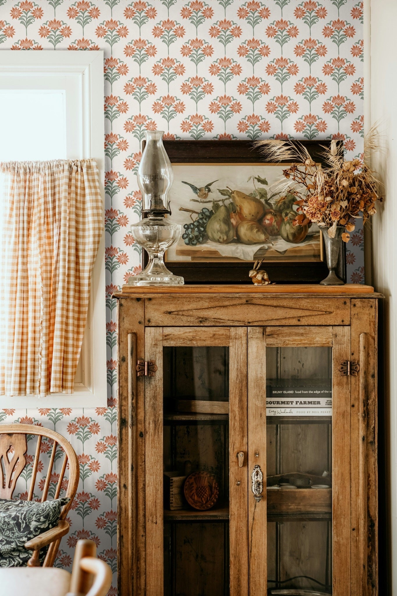 A rustic decor room featuring wooden furniture, a vintage painting, and floral damask wallpaper