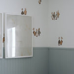 Beautiful nursery with blue wainscotting, and duck/geese decals placed above on white wall.
