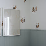 Beautiful nursery with blue wainscotting, and duck/geese decals placed above on white wall.