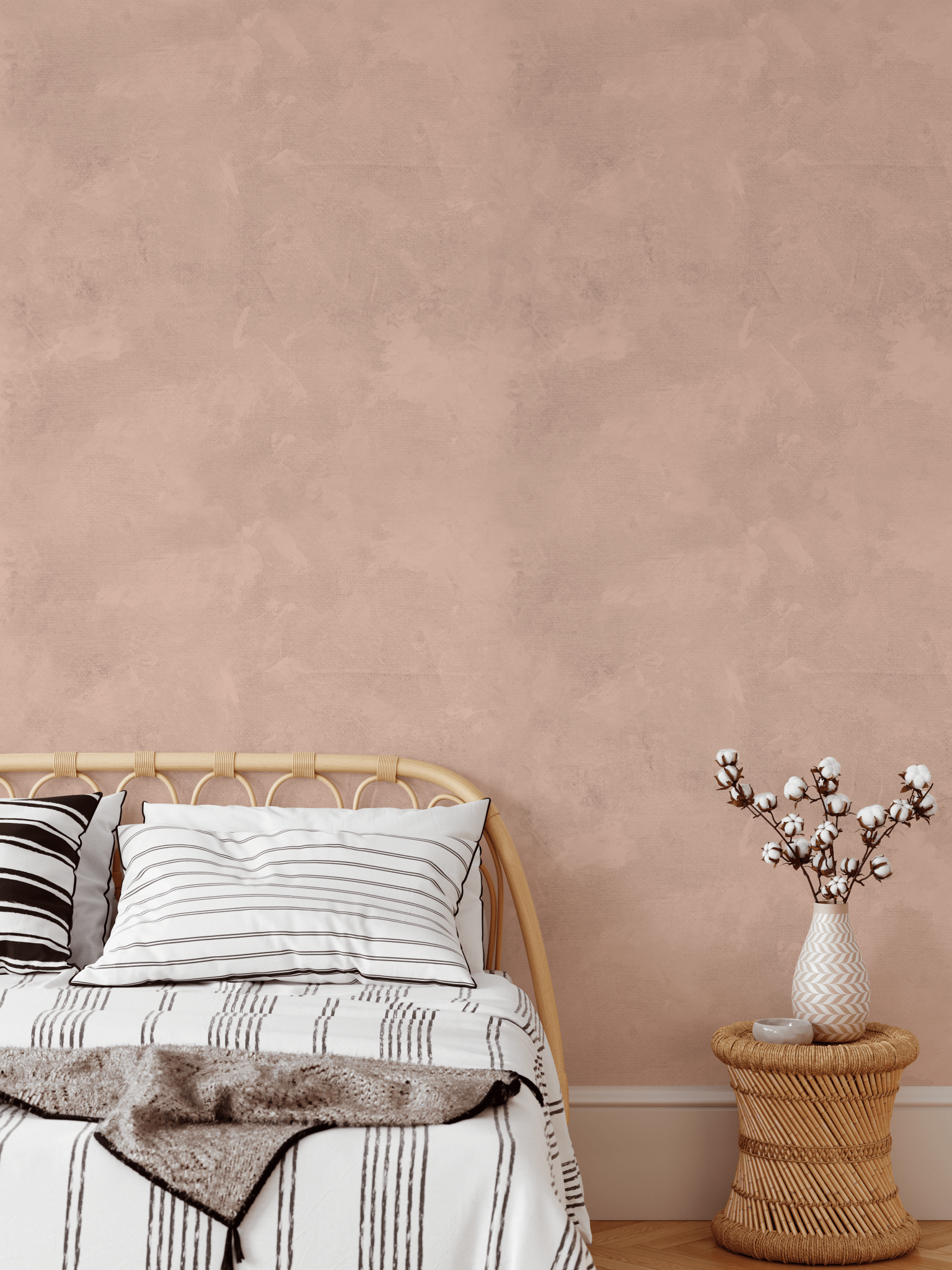 Earthy pink limewash wallpaper in a boho-inspired bedroom with woven furniture and neutral bedding for a soft, calming ambiance