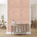 Elegant living room with pink limewash wallpaper as a feature wall, complementing neutral wood furniture and soft decor accents