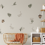 Enchanted Rabbit wall decals arranged around a crib in a woodland-themed nursery, showcasing bunnies, acorns, and greenery.