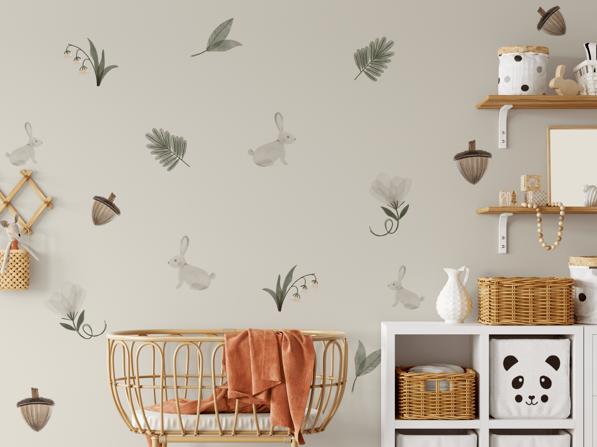 Enchanted Rabbit wall decals arranged around a crib in a woodland-themed nursery, showcasing bunnies, acorns, and greenery.