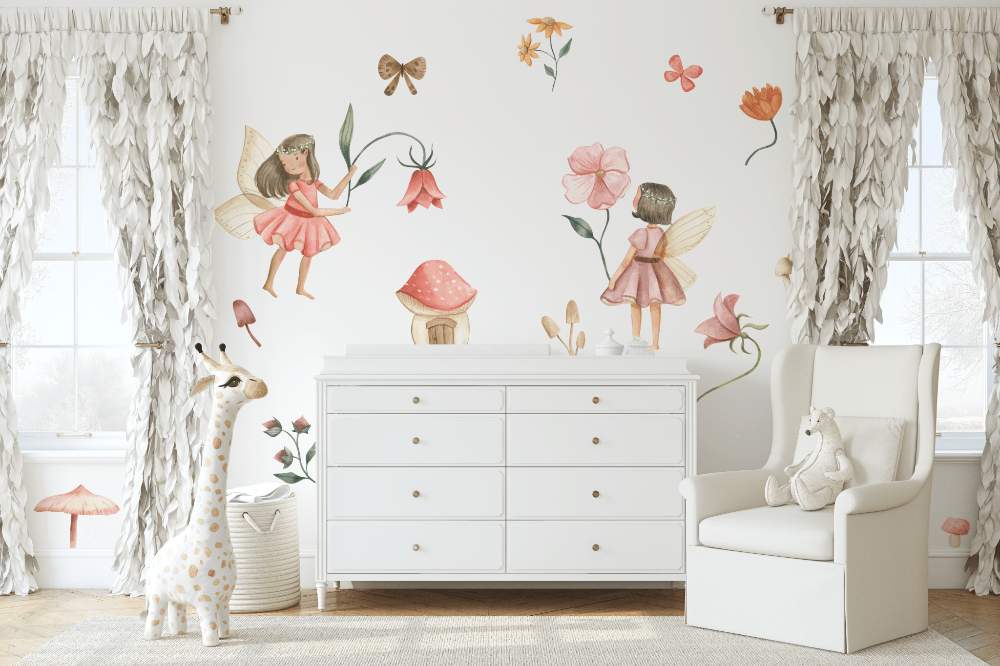 A charming nursery with fairy garden wall decals, showcasing fairies, flowers, and toadstools. The room features a white dresser, a cozy armchair, and soft white curtains, perfect for creating a serene and playful environment for a child.