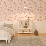 A child's bedroom with a whimsical fairy-themed wallpaper, a white bed with gray bedding, a white bookshelf with toys, and a woven basket on a patterned rug