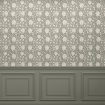 A room with a wooden floor and a light grey-green wallpaper featuring a neutral lotus flower pattern. The bottom portion of the wall has dark grey-green wainscoting with decorative molding, creating a classic and elegant look.